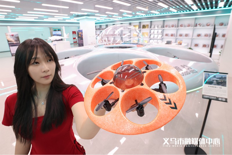载人版旁边还有一台 268 元的玩具版遥控飞碟，现场就有人拿起来展示。图片来源：义乌市融媒体中心